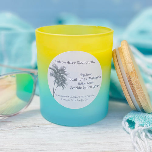 Yellow and blue ombre glass jar with reusable bamboo lid highly scented coconut wax candle with crackling wood wick Basil Lime and mandarin top layer and Seaside Lemon Grove bottom layer