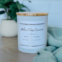 Load image into Gallery viewer, highly scented white tea and thyme coconut wax candle with crackling wood wick in reusable white glass jar and wood lid