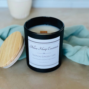 highly scented tropical ginger and lime coconut wax candle with crackling wood wick in reusable black glass jar and wooden lid