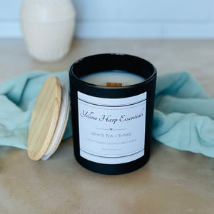 Highly scented white tea and thyme coconut wax candle with crackling wood wick in reusable glass black jar with wooden lid