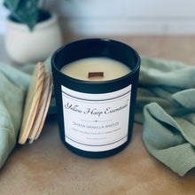 Load image into Gallery viewer, Candle with a label on a surface with greenery in the background