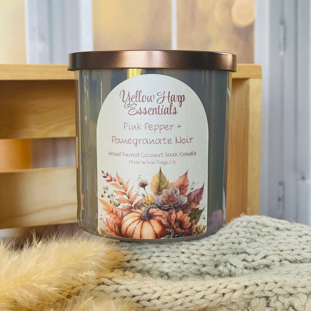 yellow harp essentials coconut wax candle with crackling wood wick in glass jar with metal lid in pink pepper pomegranate scent