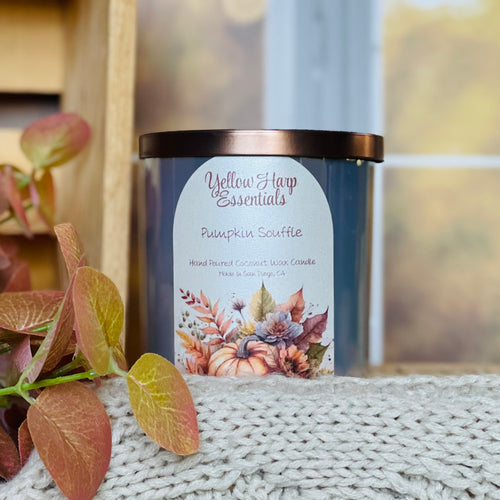 yellow harp essentials hand poured coconut wax candle with crackling wood wick in pumpkin souffle scent. shiny glass jar with bronze lid. 