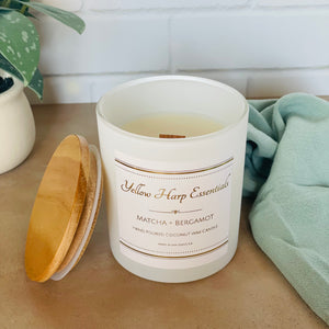 yellow harp essentials highly scented hand poured coconut wax candle with crackling wood wick in glass white jar with wood lid. Matcha and bergamot scent