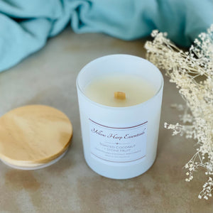 highly scented toasted coconut stone fruit coconut wax candle with crackling wood wick in reusable white glass jar and wood lid