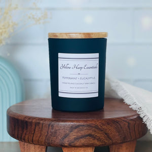 Highly scented hand poured coconut wax candle with crackling wood wick black reusable glass jar wood lid peppermint eucalyptus