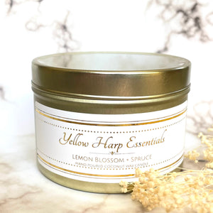 hand poured coconut wax candle with natural wood crackling tube shaped wick highly scented long lasting lemon blossom and spruce reusable gold tin and lid