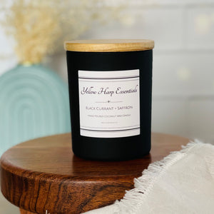 Black Currant + Saffron scented coconut wax candle with crackling wood wick reusable matte black glass jar wood lid